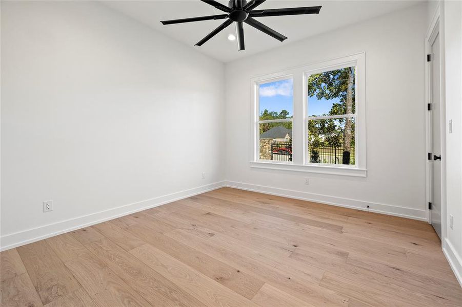 Empty room featuring light wood finished floors, ceiling fan, and recessed lighting