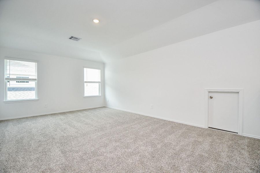 Spacious game room with plush carpeting and bright white walls, perfect for relaxation and entertainment. Spacious game room with plush carpeting and bright white walls, perfect for relaxation and entertainment.