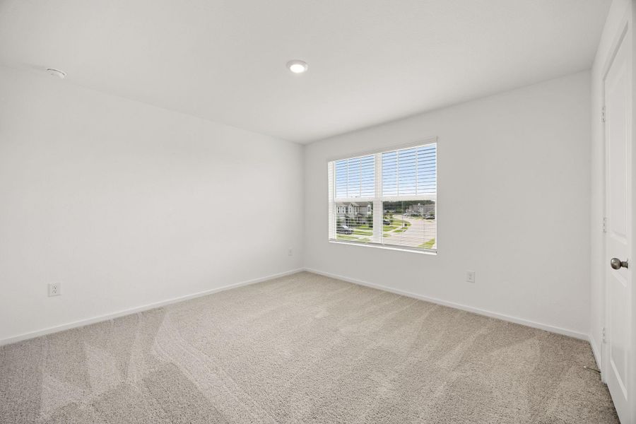 This spacious secondary bedroom features abundant natural light, neutral finishes, and a versatile layout ready to accommodate family, guests, or a home office.