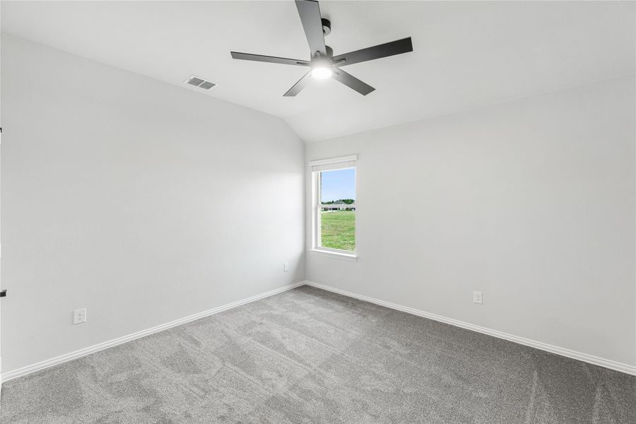 Empty bedroom with gray carpet, vaulted ceiling, ceiling fan, and single window