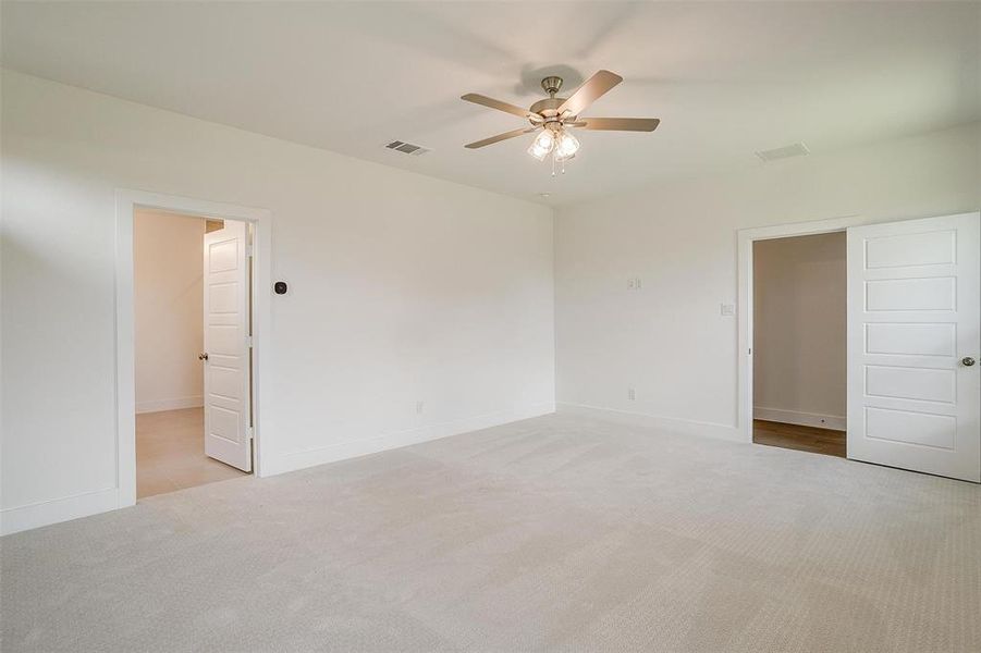 Empty room featuring light carpet and ceiling fan