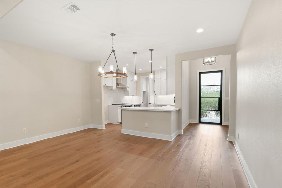 Kitchen featuring a chandelier, light wood-style floors, visible vents, and white cabinets Kitchen featuring a chandelier, light wood-style floors, visible vents, and white cabinets