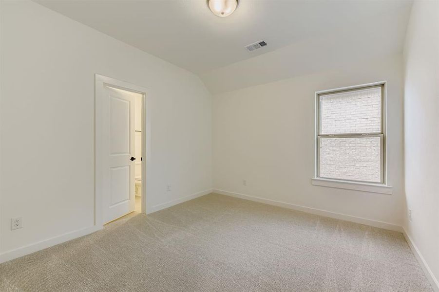 Spare room featuring light colored carpet and vaulted ceiling Spare room featuring light colored carpet and vaulted ceiling