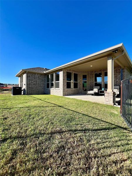 Back of house with a lawn and a patio area