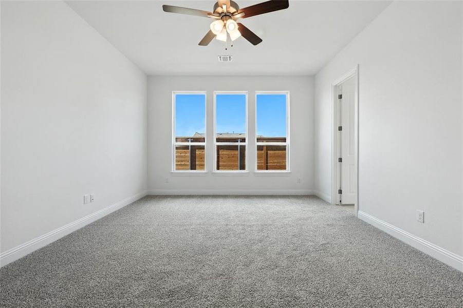 Empty room featuring carpet floors and a ceiling fan