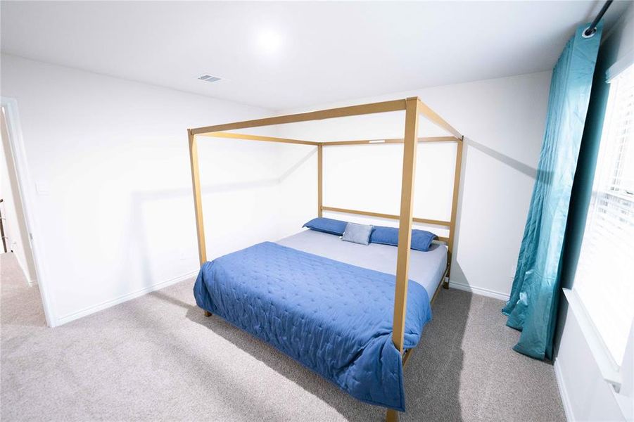 Carpeted bedroom with white walls and a window featuring blinds Carpeted bedroom with white walls and a window featuring blinds