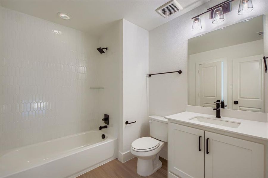 Full bathroom with shower / bath combination, vanity, and light wood finished floors Full bathroom with shower / bath combination, vanity, and light wood finished floors