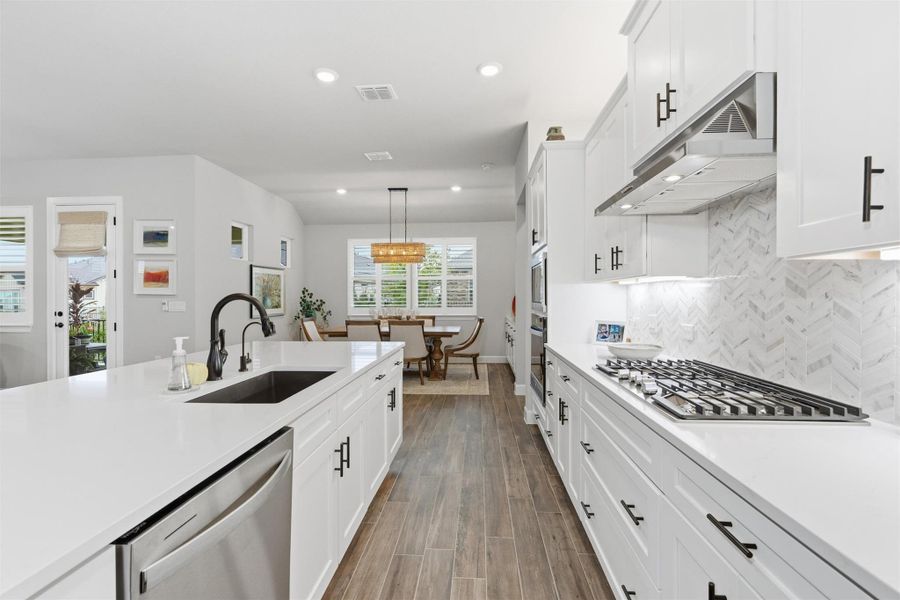 Close-up of the kitchen with lots of 42" cabinets, quartz countertops, gas cooktop, oven & microwave. Stainless french door refrigerator is included with the home Close-up of the kitchen with lots of 42" cabinets, quartz countertops, gas cooktop, oven & microwave. Stainless french door refrigerator is included with the home