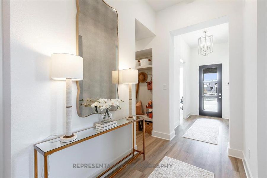 Foyer with wood finished floors and a chandelier