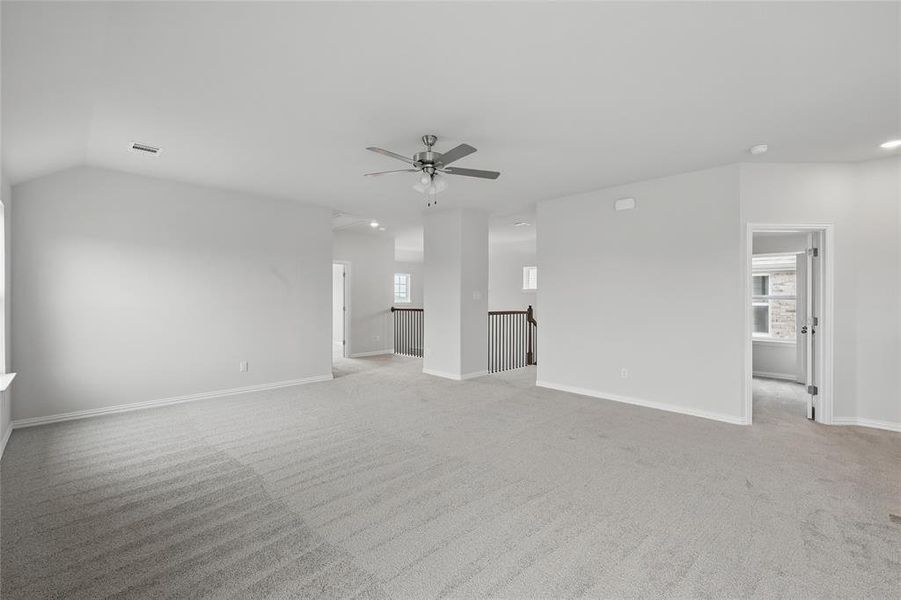 Unfurnished room featuring light carpet and plenty of natural light
