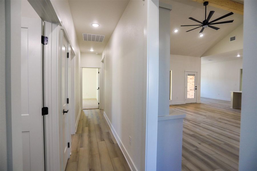 Corridor featuring light wood-type flooring, recessed lighting, and vaulted ceiling