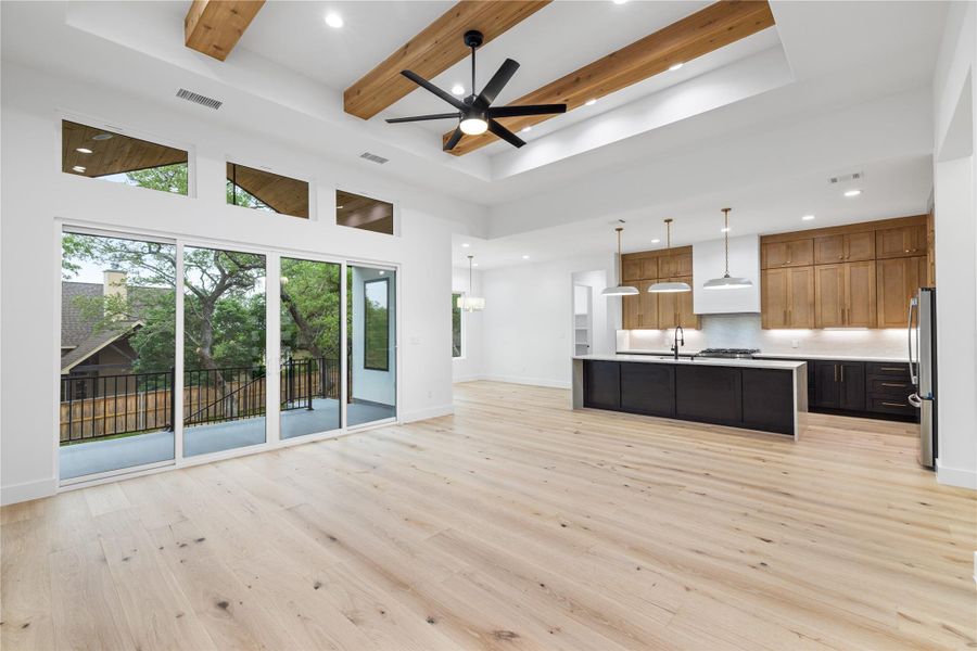 Kitchen/Living area featuring open floor plan, beamed ceiling, engineered white oak wood floors, and recessed lighting. Kitchen/Living area featuring open floor plan, beamed ceiling, engineered white oak wood floors, and recessed lighting.
