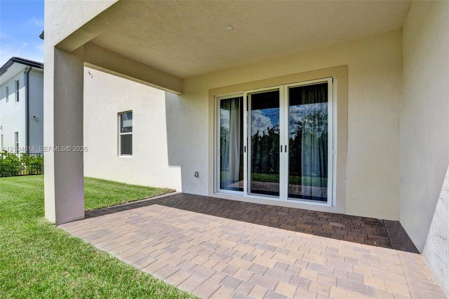 Covered patio area featuring a brick paver surface
