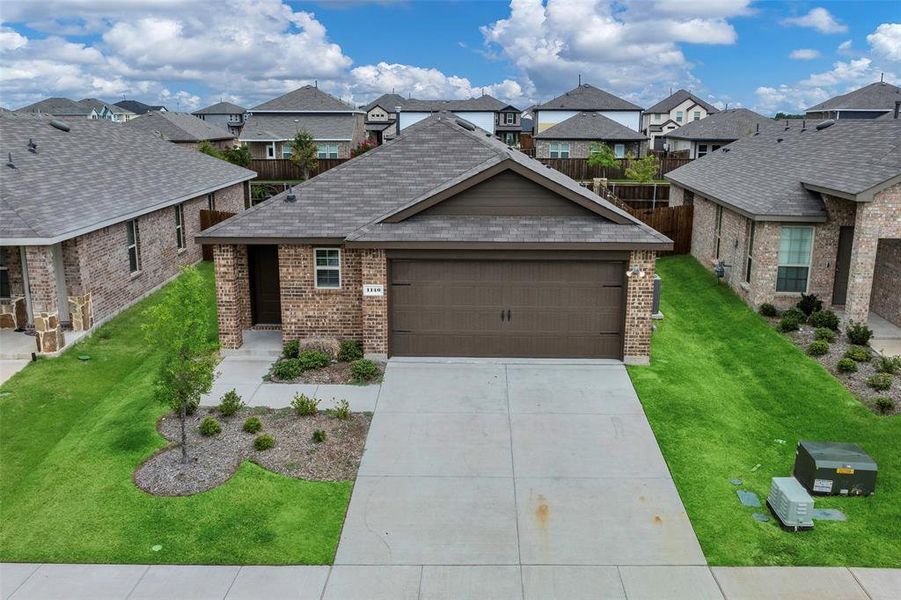 View of front facade featuring a garage and a front yard