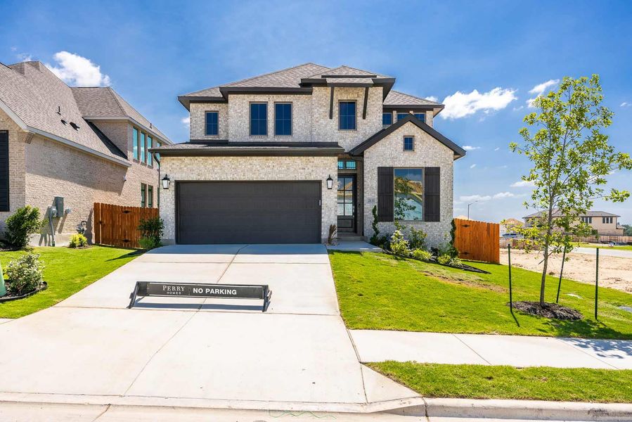 Front exterior of a new home in Lariat 45', Liberty Hill, TX, highlighting curb appeal (Image 2). Front exterior of a new home in Lariat 45', Liberty Hill, TX, highlighting curb appeal (Image 2).