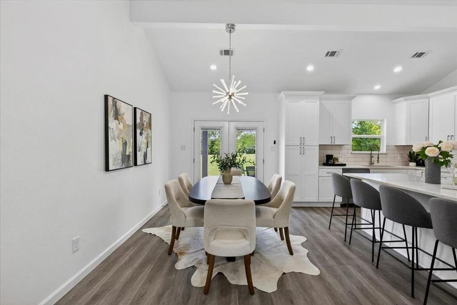 Open-concept living space featuring wood-finish flooring, vaulted ceilings, and recessed lighting
