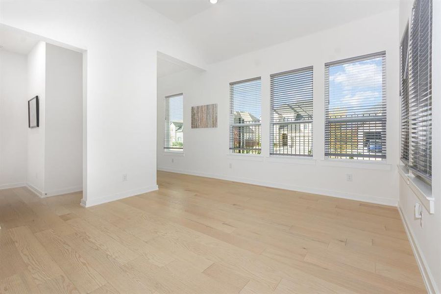 Empty room featuring vaulted ceiling and light wood finished floors Empty room featuring vaulted ceiling and light wood finished floors