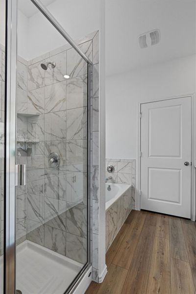 Full bathroom with a bath, wood finished floors, and a shower stall