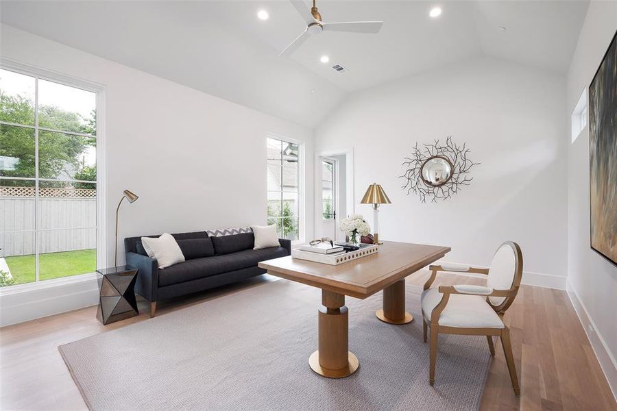 Living room featuring ceiling fan, light hardwood / wood-style floors, and vaulted ceiling