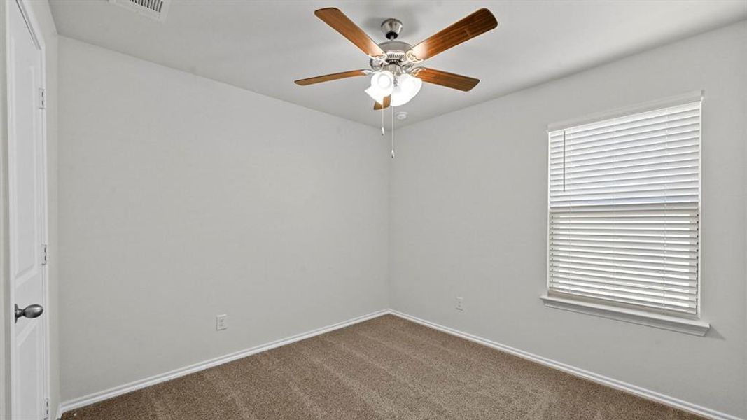 Unfurnished room featuring dark carpet and ceiling fan