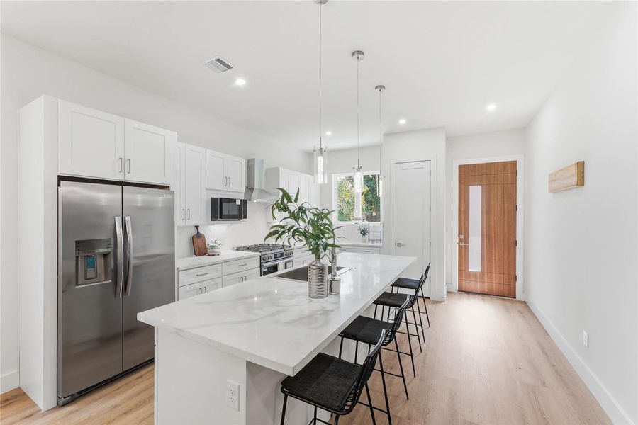 The first-floor kitchen features quartz countertops, crisp white cabinetry, a spacious sink, and a full suite of brand-new stainless steel appliances, complemented by a modern range hood and clean, contemporary finishes. The first-floor kitchen features quartz countertops, crisp white cabinetry, a spacious sink, and a full suite of brand-new stainless steel appliances, complemented by a modern range hood and clean, contemporary finishes.