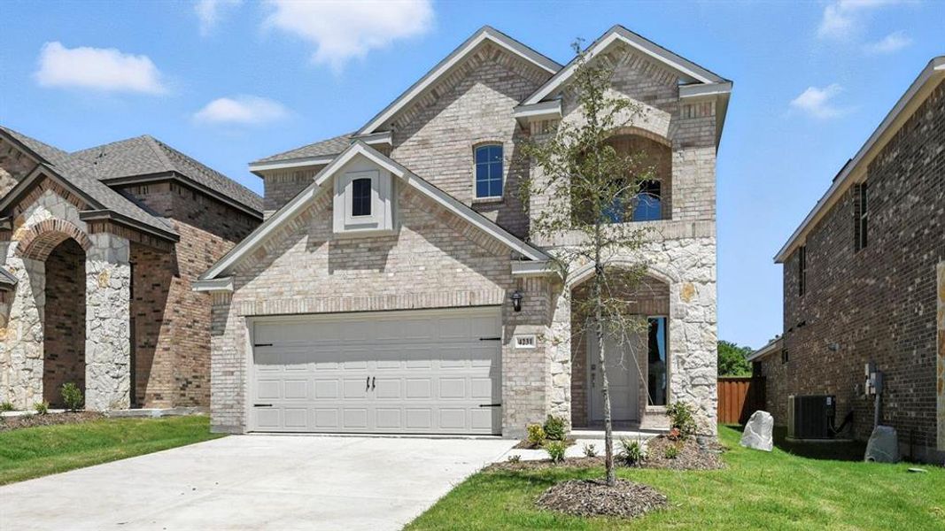 French country inspired facade featuring driveway, a garage, brick siding, and a front yard French country inspired facade featuring driveway, a garage, brick siding, and a front yard