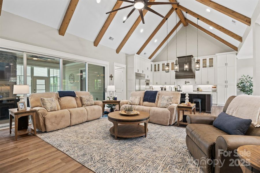 Great Room with wood beams and large 10-blade ceiling fan.