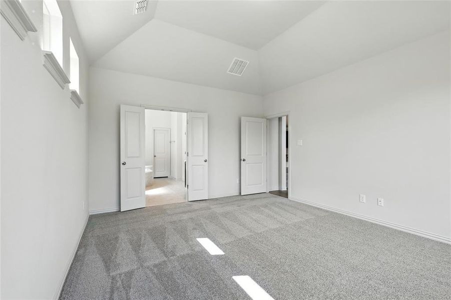 Unfurnished bedroom featuring carpet and lofted ceiling