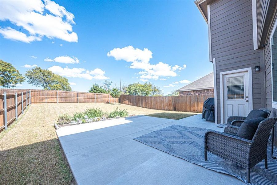 Fenced backyard with a patio and area for grilling