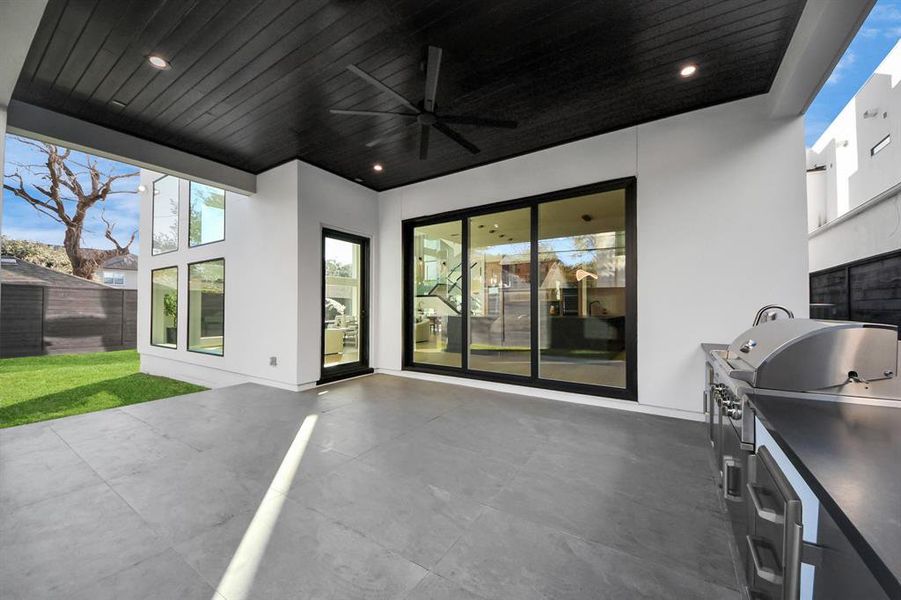 Modern wood plank ceiling with a modern ceiling fan, and with sleek tile flooring offering a stylish and comfortable outdoor retreat for relaxing or entertaining.