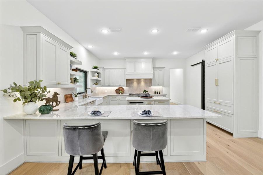 Kitchen with good sized peninsula island and center island.  Note the Thermidor built in smart refrigerator and monogram range!!!