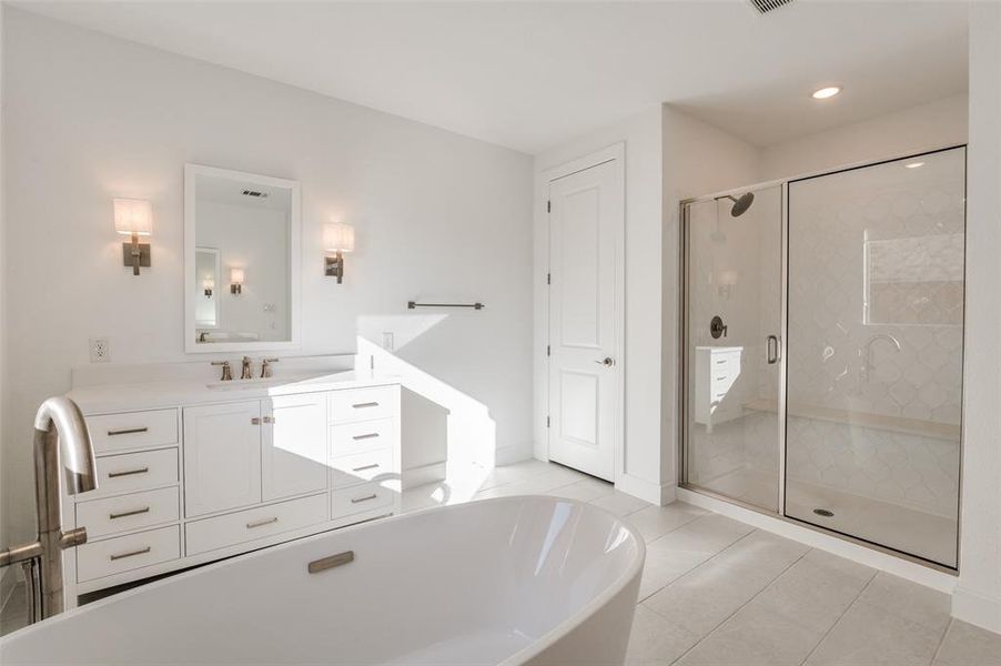 Bathroom featuring vanity, a freestanding bath, light tile patterned flooring, a shower stall, and recessed lighting Bathroom featuring vanity, a freestanding bath, light tile patterned flooring, a shower stall, and recessed lighting