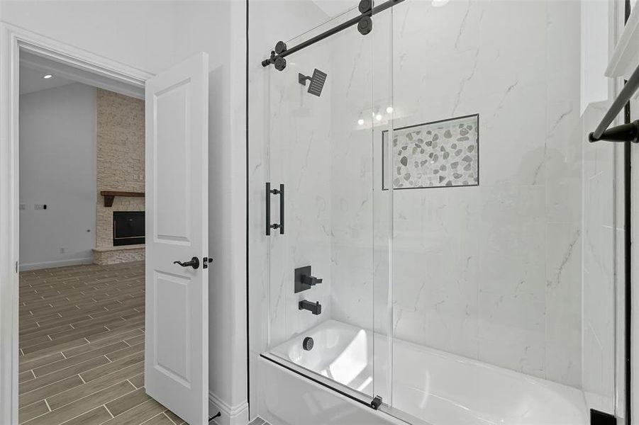Bathroom with enclosed tub / shower combo, wood finish floors, a fireplace, and recessed lighting Bathroom with enclosed tub / shower combo, wood finish floors, a fireplace, and recessed lighting