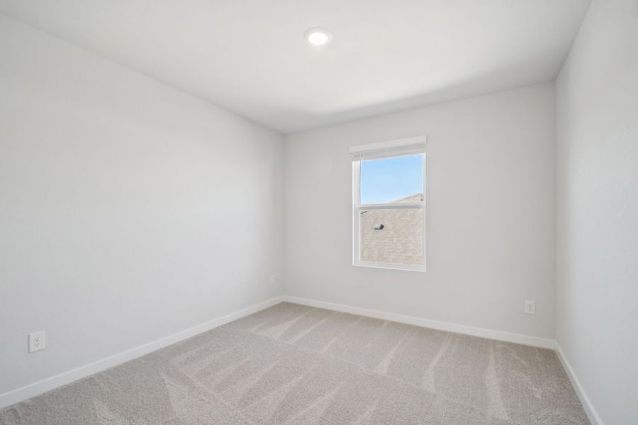 A room with a window and a rug.