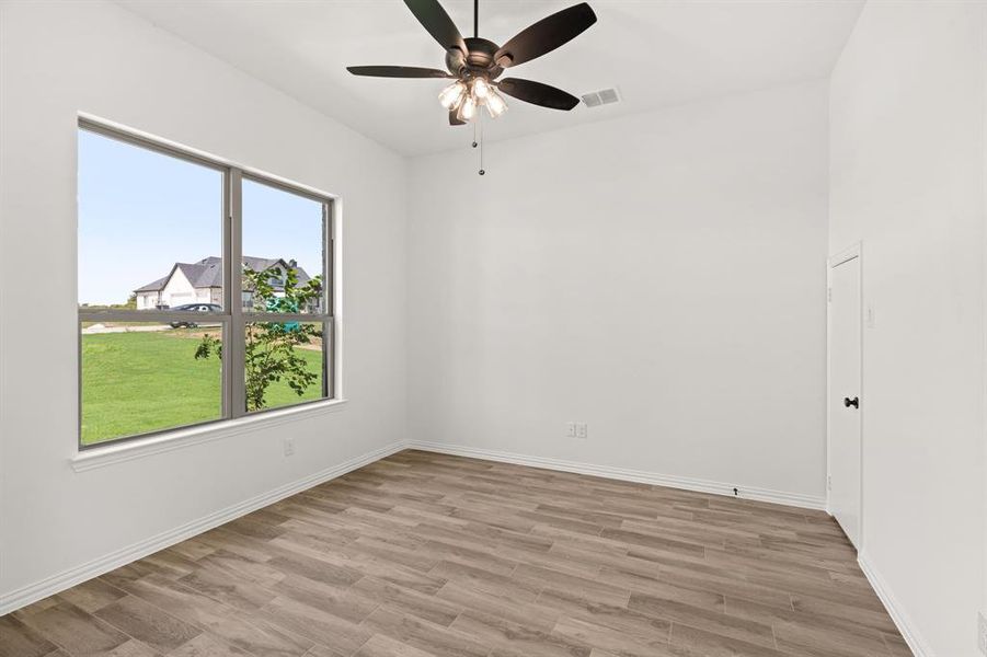 Empty room featuring light wood-style flooring and a ceiling fan Empty room featuring light wood-style flooring and a ceiling fan