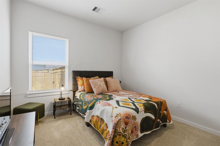 Bedroom featuring light colored carpet and baseboards