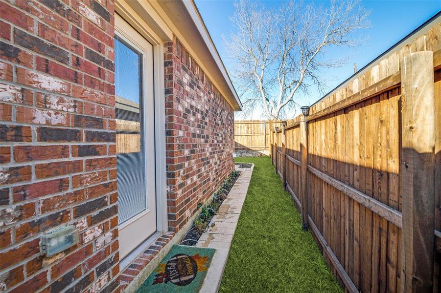 View of property exterior with fence and brick siding