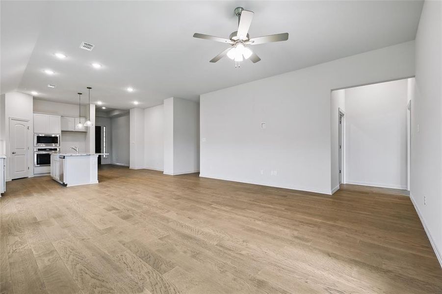 Unfurnished living room with ceiling fan, recessed lighting, and light wood-style floors