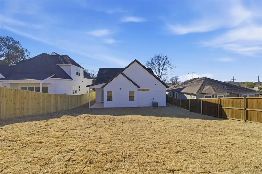 Back of house with a fenced backyard and a patio area