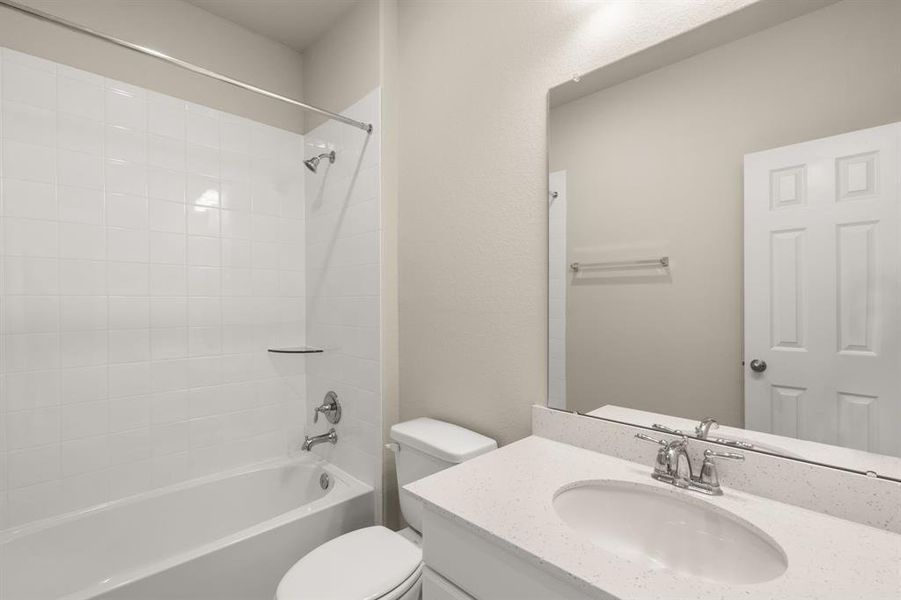 The secondary bath features tile flooring, white cabinetry and light countertops and a shower/tub combo. Perfect for accommodating any visiting family and friends.