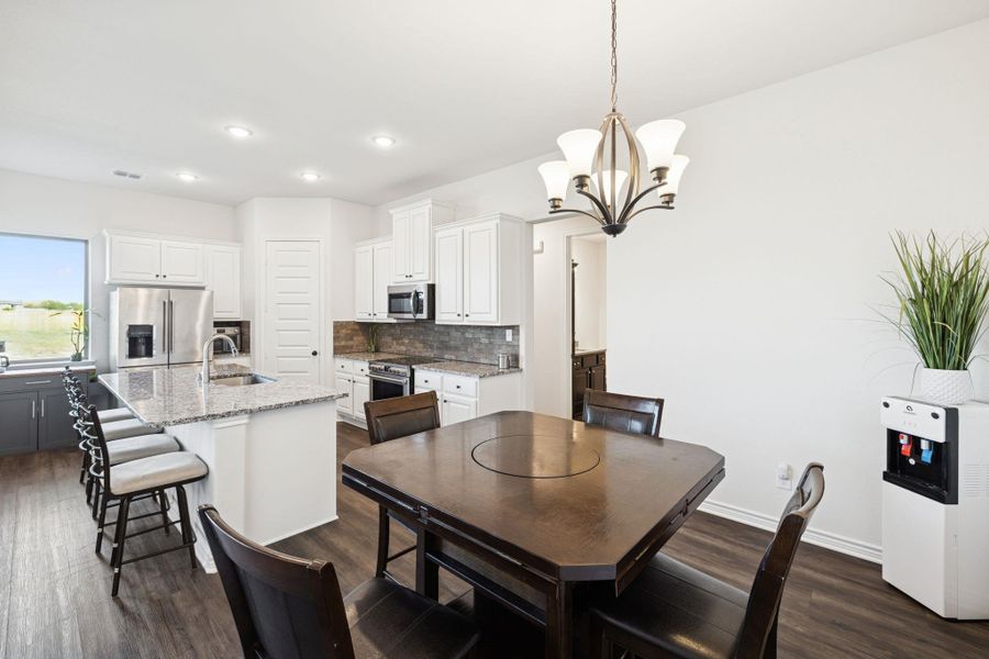 Dining area featuring dark wood-type flooring, a chandelier, and recessed lighting Dining area featuring dark wood-type flooring, a chandelier, and recessed lighting