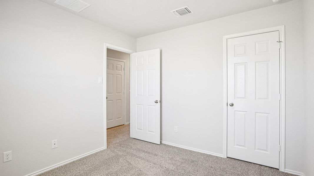 Neutral-toned room featuring light gray carpet flooring and white painted walls