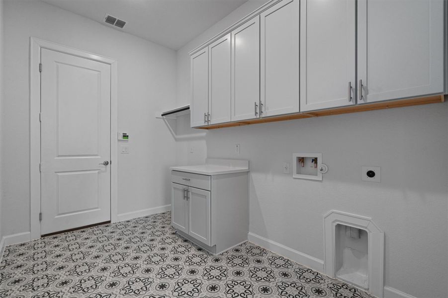 Laundry room featuring hookup for a washing machine, electric dryer hookup, and cabinet space Laundry room featuring hookup for a washing machine, electric dryer hookup, and cabinet space