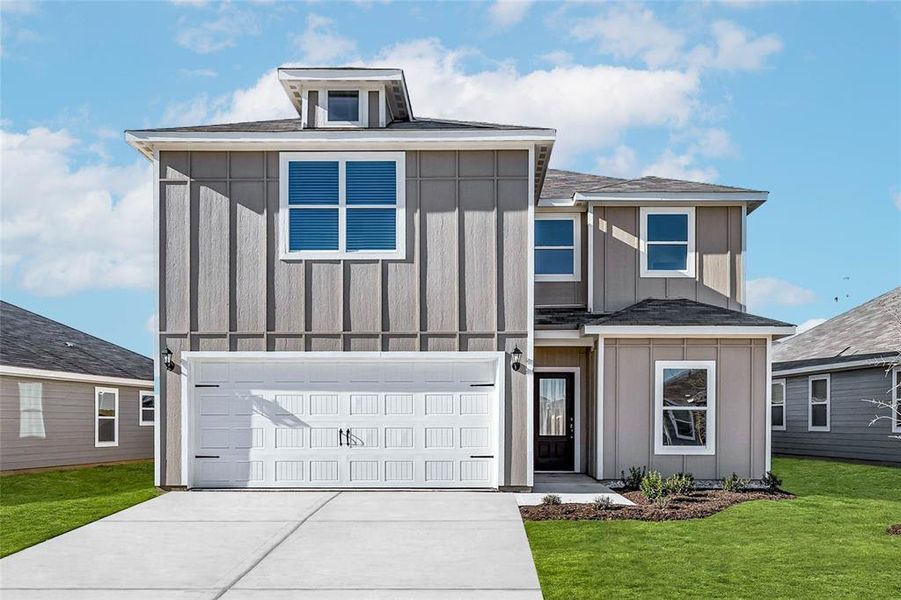 View of front of home with a garage and a front yard