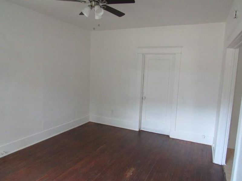 Spare room with dark wood-type flooring and ceiling fan Spare room with dark wood-type flooring and ceiling fan