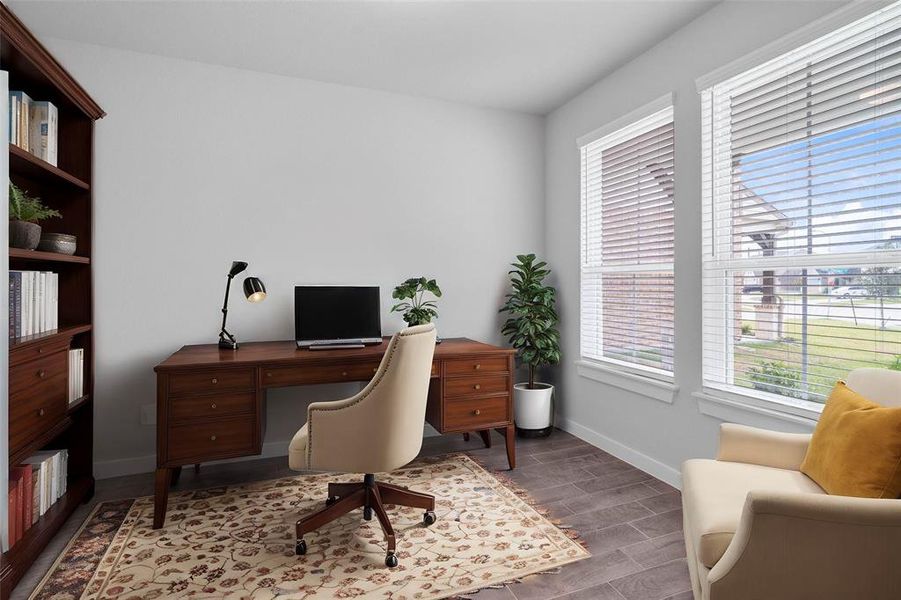 Quietly nestled in front of the home is the handsome home office. Featuring wood-like tile flooring, high ceilings, large windows with privacy blinds and custom paint.