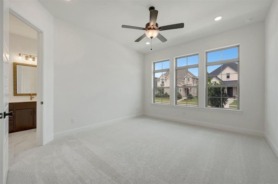 Carpeted room featuring three large windows, a ceiling fan, and recessed lighting