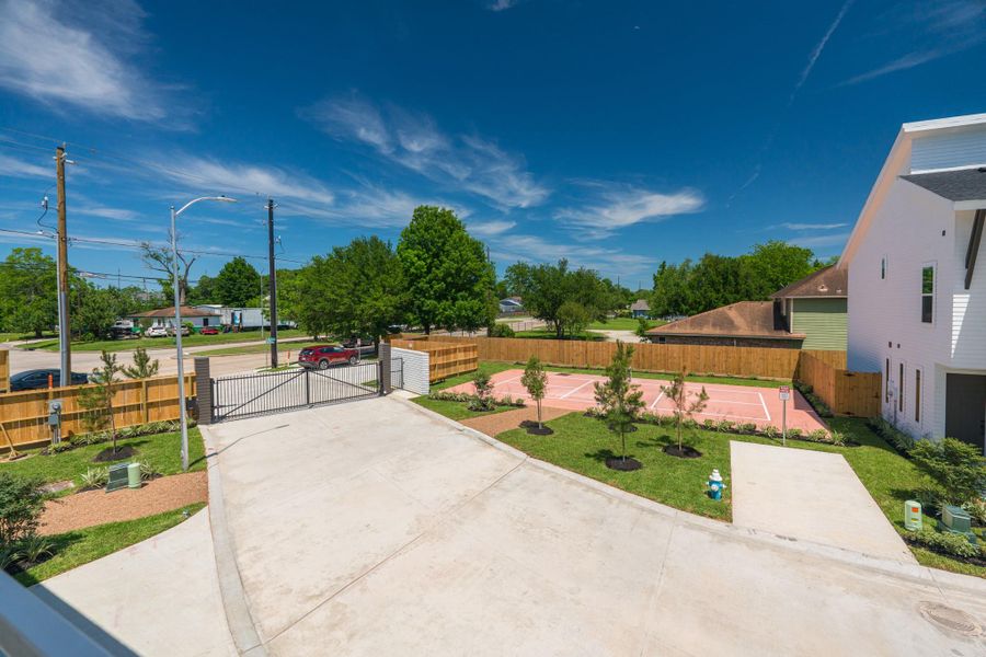This photo shows a gated residential property with a spacious driveway and a fenced backyard featuring a basketball court. The area is landscaped with young trees and greenery, providing a welcoming atmosphere.Photo Disclaimer: Photos are representative of the community and may depict a similar floor plan, model home, or previously completed residence. This photo shows a gated residential property with a spacious driveway and a fenced backyard featuring a basketball court. The area is landscaped with young trees and greenery, providing a welcoming atmosphere.Photo Disclaimer: Photos are representative of the community and may depict a similar floor plan, model home, or previously completed residence.