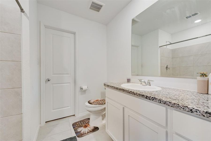 Bathroom with light tile patterned flooring, vanity, and a shower Bathroom with light tile patterned flooring, vanity, and a shower