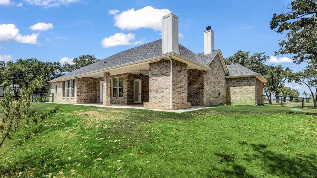 Back of house with a patio area and a yard